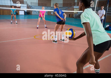 Volleyball players practicing in court Stock Photo