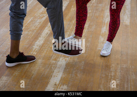 Low section of dancers practicing on floor in studio Stock Photo