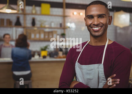 Portrait of smiling owner standing in cafe Stock Photo