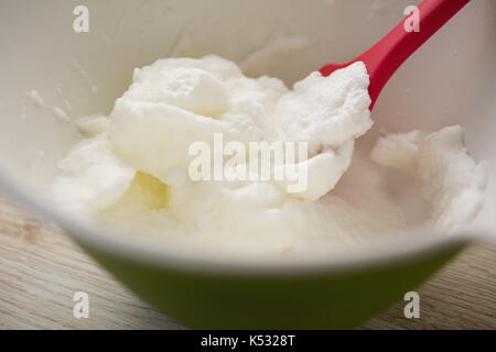 Close up of spatula and whipped cream in bowl on table Stock Photo