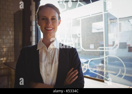 Portrait of confident female owner by window in cafe Stock Photo