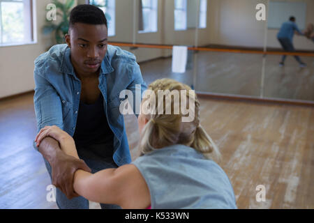 Young man looking at friend while dancing in studio Stock Photo