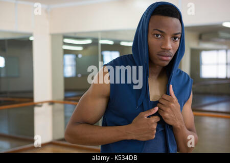 Portrait of young male dancer in hooded shirt at studio Stock Photo