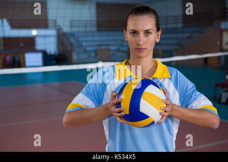 Portrait of young female sportsperson holding volleyball Stock Photo
