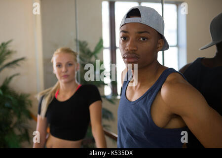 Portrait of male dancer with young friend by mirror in studio Stock Photo