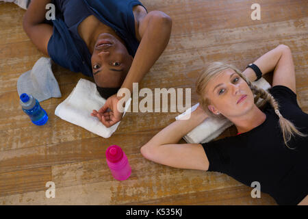 Portrait of tired dancers relaxing on hardwood floor in studio Stock Photo