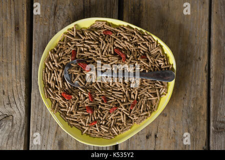 Cereal bran sticks with spoon in plate on wooden table Stock Photo