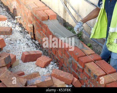 SELANGOR, MALAYSIA -JANUARY 15, 2017: Bricklayer lay clay bricks block and stacked it together using cement mortar to form walls at the construction Stock Photo