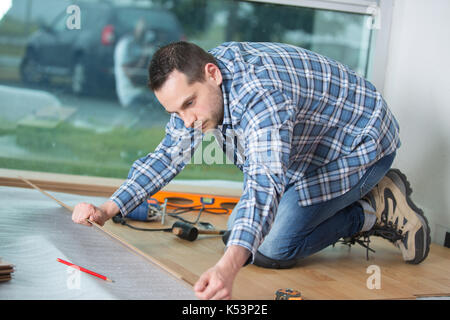 man laying laminate flooring in construction concept Stock Photo