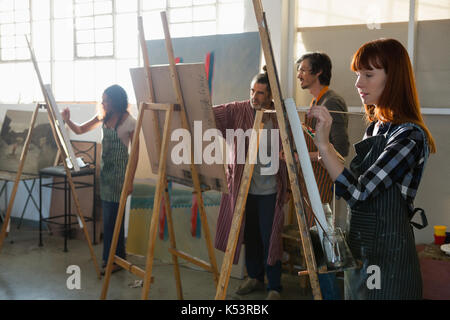 Adult students painting on canvas in art class Stock Photo