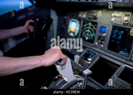 Cropped hands of male pilot pushing lever in airplane cockpit Stock Photo