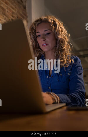 Woman using laptop computer at table in cafe Stock Photo