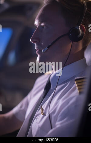 Side view of young male pilot concentrating on flying airplane Stock Photo