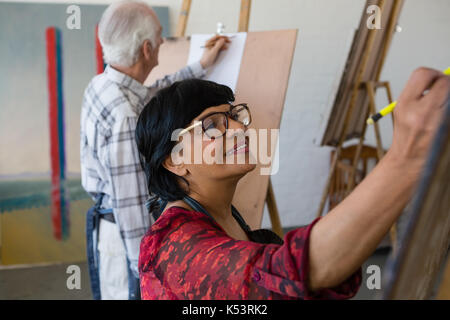 High angle view of senior male and female artists painting while in art class Stock Photo