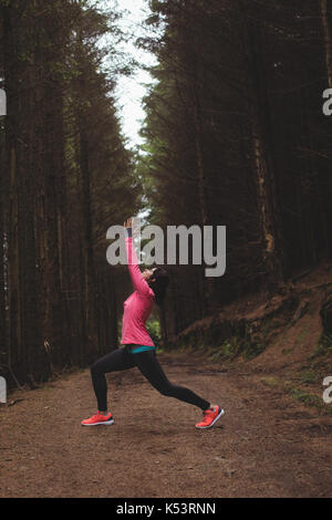 Woman performing stretching exercise in forest Stock Photo