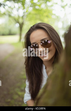 Portrait of woman posing on tree trunk at forest Stock Photo