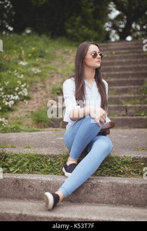 Thoughtful woman in sunglasses at forest Stock Photo