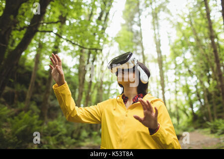 Woman using reality virtual headset in forest Stock Photo