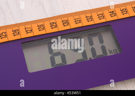 Tape measure on household digital bathroom scale for weight of human body, concept of healthy lifestyle and slimming Stock Photo