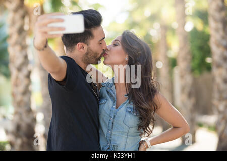 Happy couple of lovers spend free time on coast: pretty female rides on  boyfriend`s back, make selfie, pose against sea landscape. Cheerful man  gives piggy back to girlfriend. Love, relationship Stock Photo |