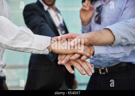 Close up on men hands holding together in gesture of unity Stock Photo
