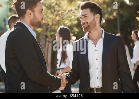 Portrait of two businessmen shaking hands outside Stock Photo
