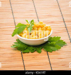 cooked sweet corn seeds in a bowl on a wooden table. canned corn Stock ...