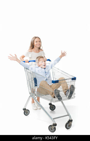 sister riding brother in shopping cart Stock Photo