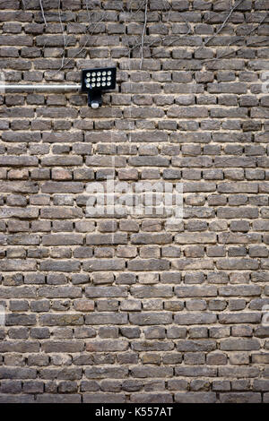 An old nostalgic brick wall with a wall lamp. Stock Photo