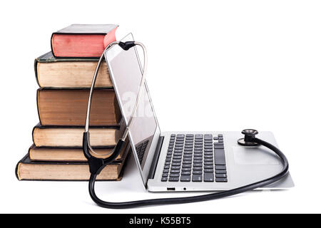 Silver laptop with black stethoscope and old books pile isolated on white background Stock Photo