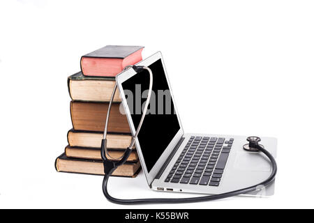 Silver laptop with black stethoscope and old books pile isolated on white background Stock Photo