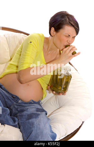 Pregnant woman eats a pickle from a jar Stock Photo