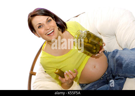 Pregnant woman eats a pickle from a jar Stock Photo