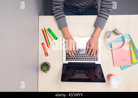 Male student working with laptop on desk. Top view Stock Photo