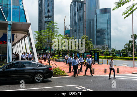 Chinese office workers stroll outside in Houhai district, Shenzhen, Guangdong Province, China Stock Photo