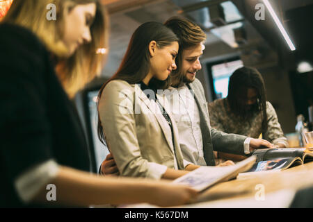 People reading and conversing in a bar Stock Photo