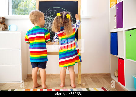 little child drawing on the blackboard Stock Photo