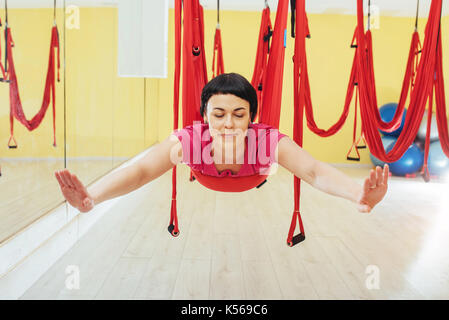 Young beautiful woman practicing yoga Fly with a hammock in studio. Stock Photo