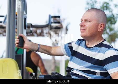 Disabled man working out with trainer. Stock Photo