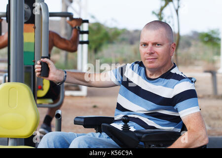 Disabled man working out with trainer. Stock Photo