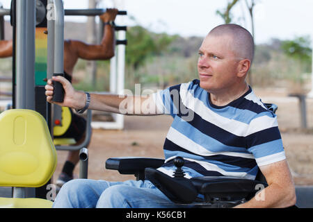 Disabled man working out with trainer. Stock Photo
