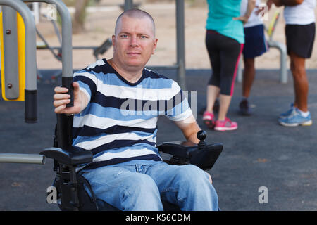 Disabled man working out with trainer. Stock Photo