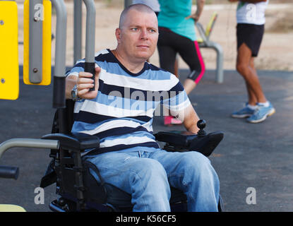 Disabled man working out with trainer. Stock Photo