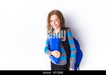 girl of 9 years in a school uniform poses in studio. Stock Photo