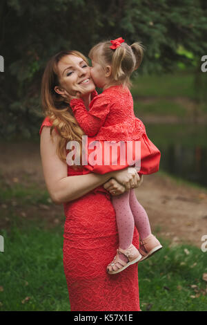 happy mother with daughter in red dresses Stock Photo