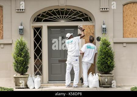 Workers secure plywood covering on a historic home in preparation for Hurricane Irma September 8, 2017 in Charleston, South Carolina. Imra is expected to spare the Charleston area but hurricane preparations continue as Irma leaves a path of destruction across the Caribbean. Stock Photo