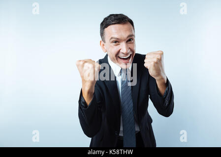 Happy cheerful man holding fists Stock Photo