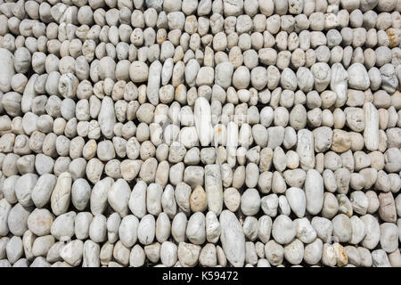 Group of assorted smooth rocks lined up in rows in closeup, full frame detail. Stock Photo