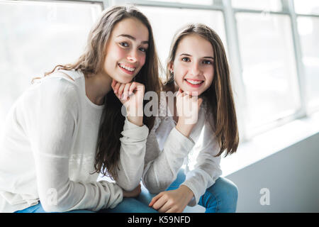 closeup portrait of hugging 2 beautiful young women having fun Stock Photo