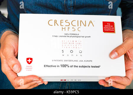 Paphos, Cyprus - November 13, 2015 Woman hands with Crescina HFSC Re-Growth Anti-Hair Loss Complete Treatment box. Crescina HFSC preserves cell longev Stock Photo